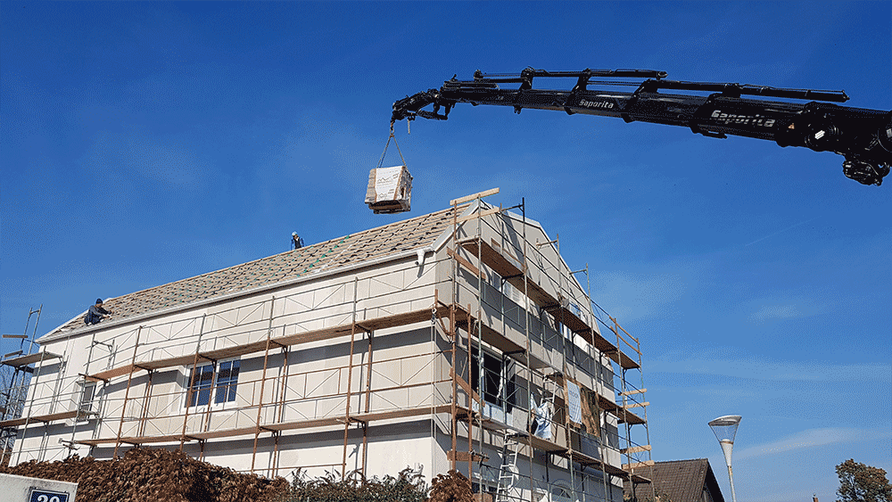 Dachdeckung: Ein Kran befördert die Dachziegel aufs Dach