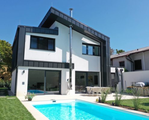 Blick auf den Haus Neubau in Mödling mit Pool im Vordergrund